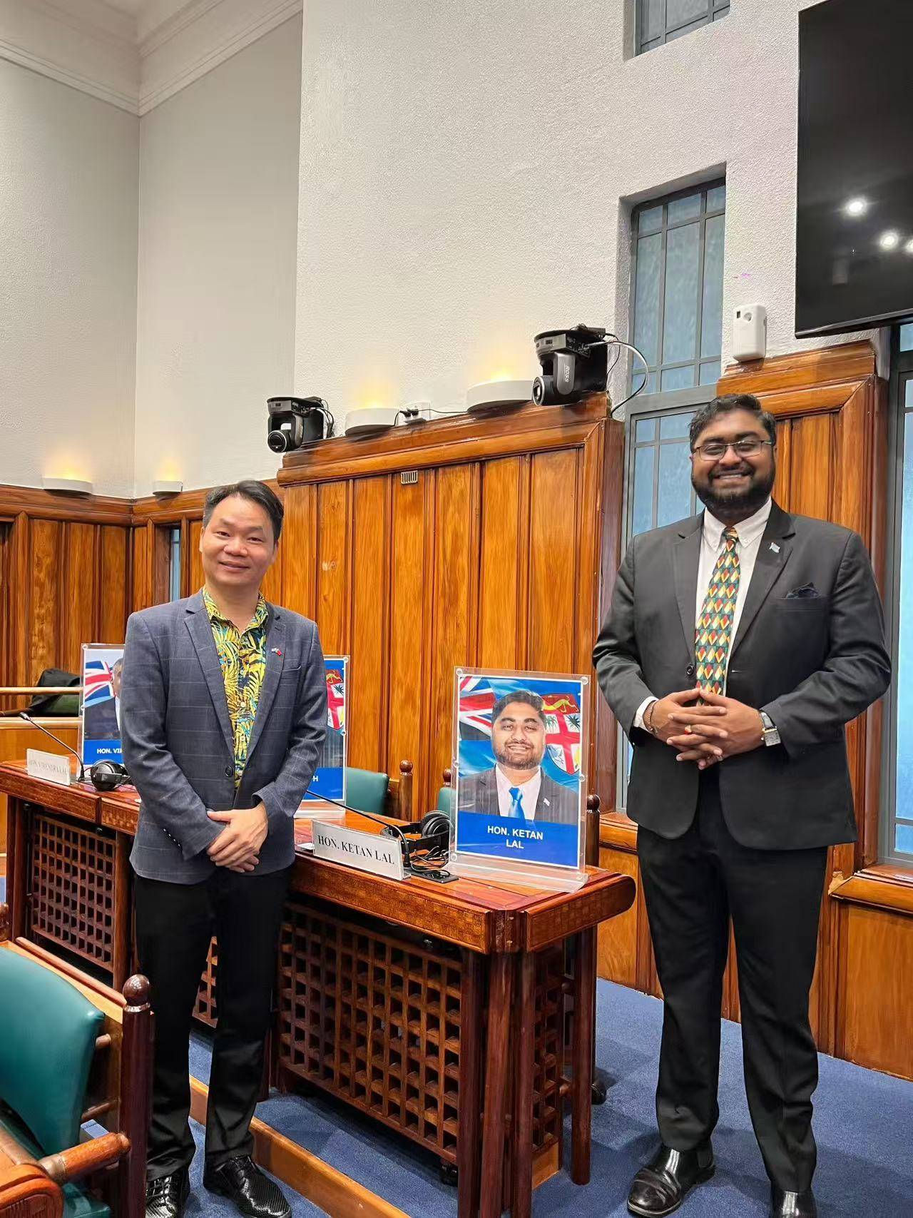 Ketan Lal and Huang Ruitian standing together in the parliamentary chamber